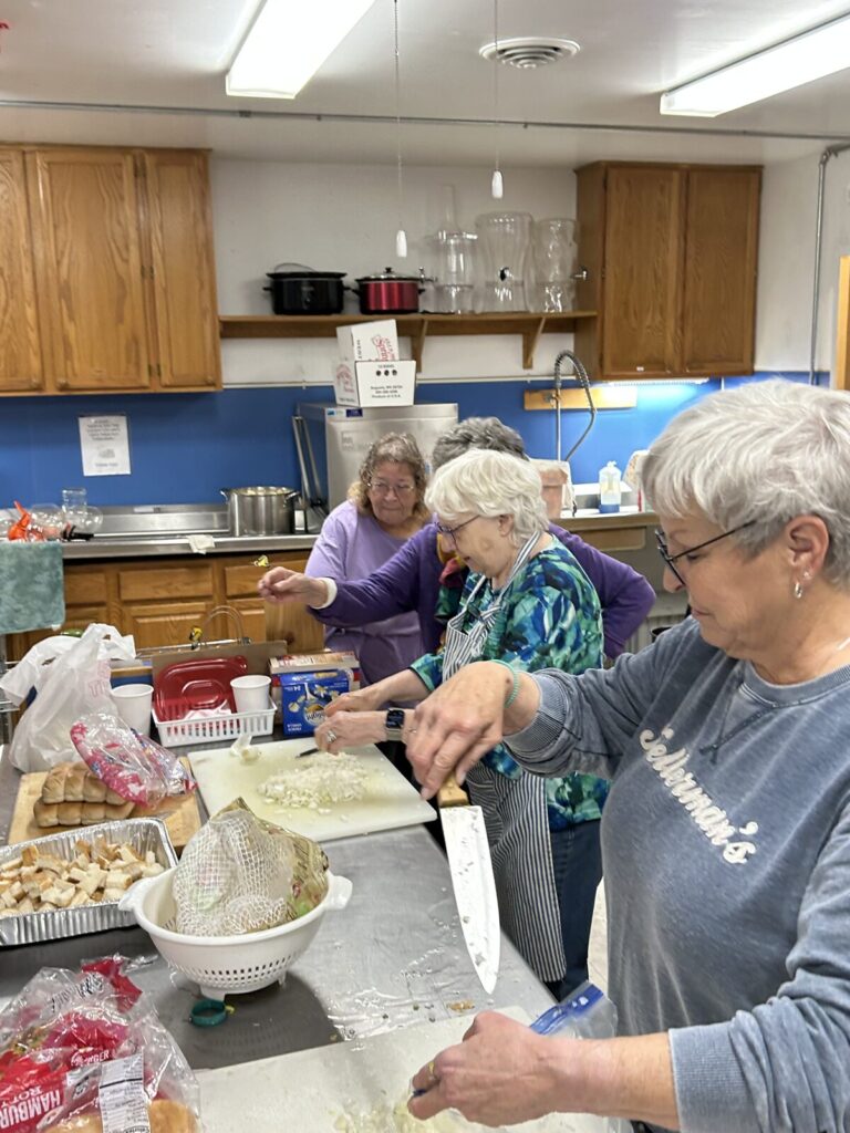 Volunteers preparing food together at the kitchen counter