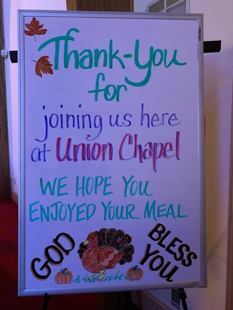 Hand-lettered sign reading Thank you for joining us here at Union Chapel, we hope you enjoyed your meal, God bless you