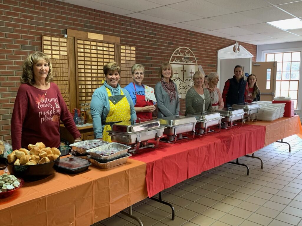 Volunteers standing ready behind the buffet tables in the Fellowship Hall