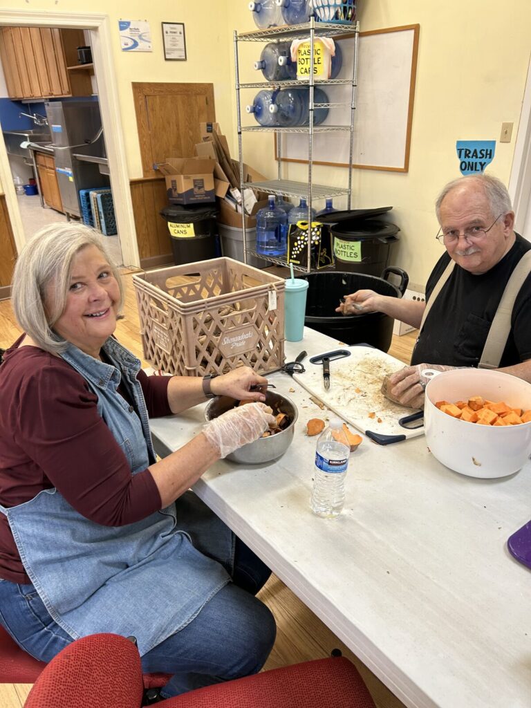 Volunteers at a table cutting vegetables for the free community meal