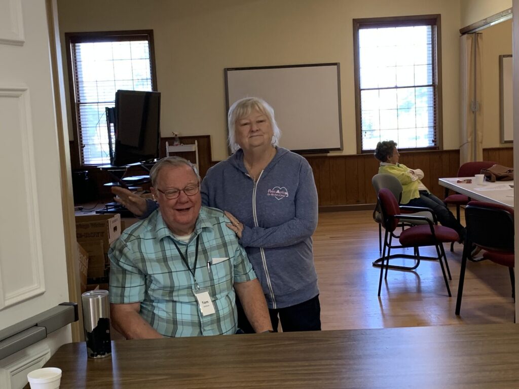 Two volunteers sitting together in the Fellowship Hall