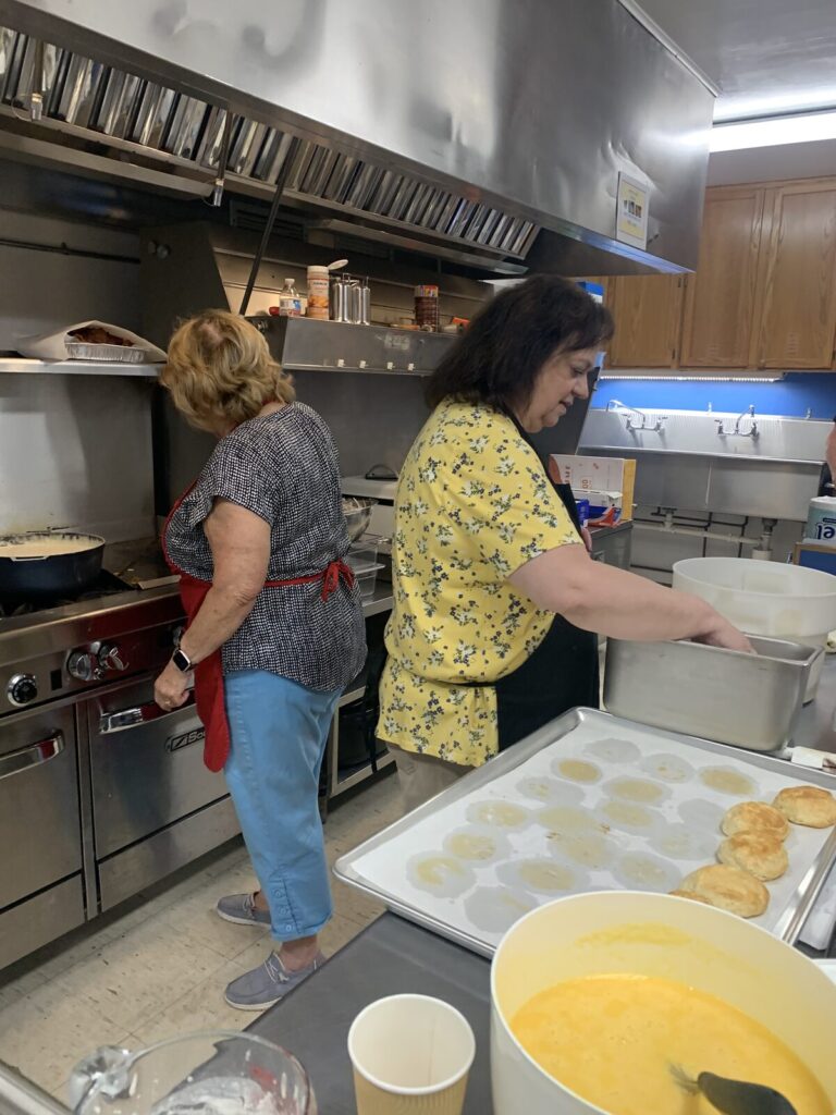 Volunteers making biscuits and gravy at the kitchen stove
