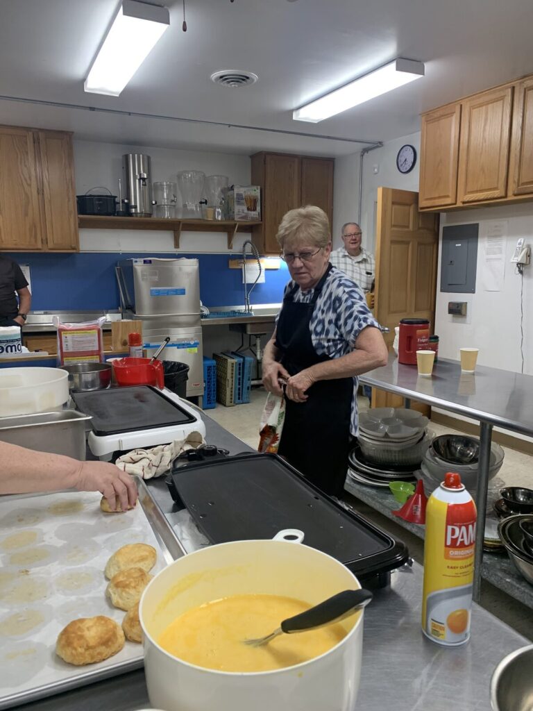 Volunteers cooking breakfast on the griddle and stove