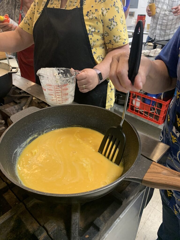 Scrambled eggs cooking in a large skillet