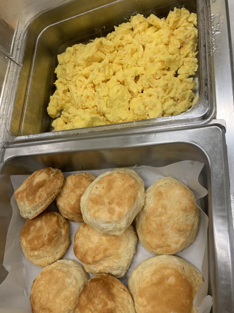 Pans of scrambled eggs and fresh baked biscuits