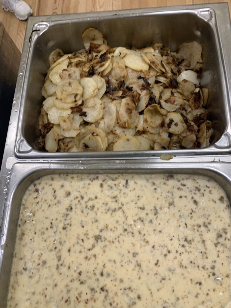 Pans of fried potatoes and sausage gravy
