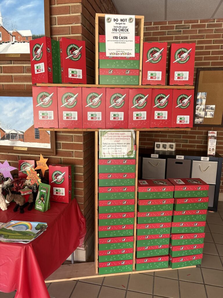 Shelves of red and green Samaritan's Purse Operation Christmas Child shoeboxes on display at Union Chapel