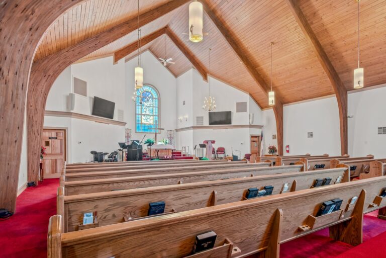 Wide view of the sanctuary pews and vaulted wood ceiling